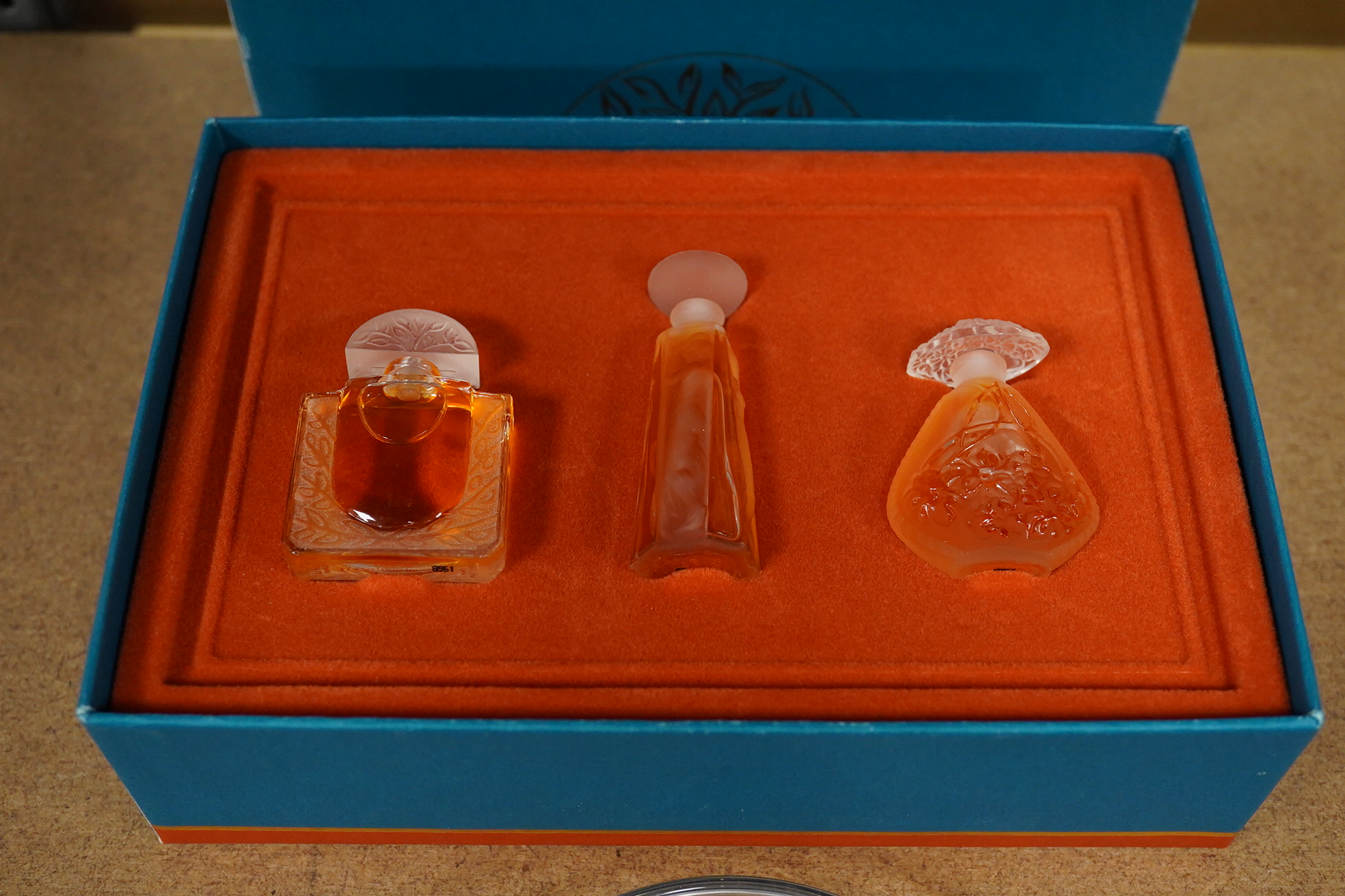 A Lalique bird pin dish and a Lalique perfume trio, Les Introuvables, in original box, pin dish 9cm